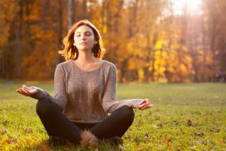 dívka, která medituje v podzimní krajině