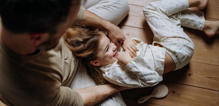 Otec s dcerou ležící na podlaze. Vypadá to jako idylka, viď?