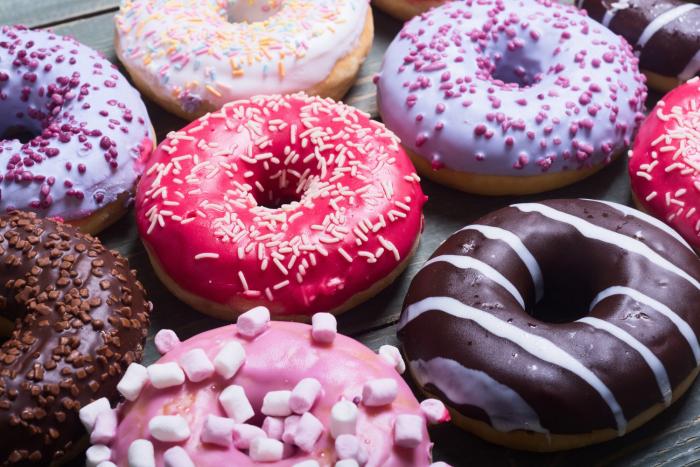 Donuty se vyrábějí z kynutého těsta a chutnají podobně jako české koblihy.